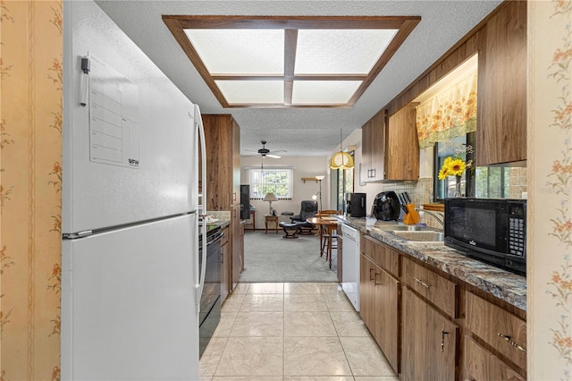 kitchen featuring ceiling fan, a textured ceiling, white appliances, and light colored carpet