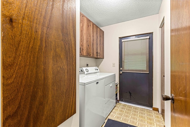 clothes washing area featuring light tile patterned floors, cabinets, a textured ceiling, and washer and dryer