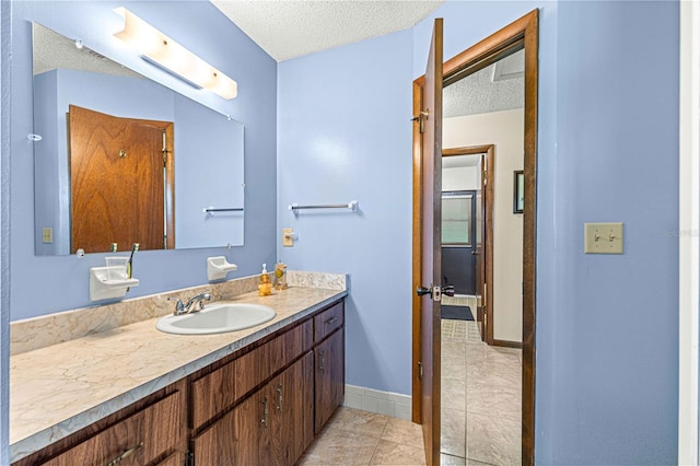 bathroom with vanity, a textured ceiling, and tile patterned flooring