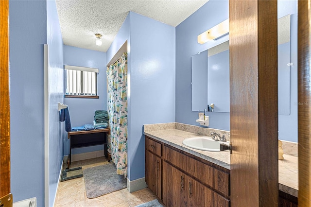 bathroom featuring a textured ceiling, tile patterned floors, and vanity