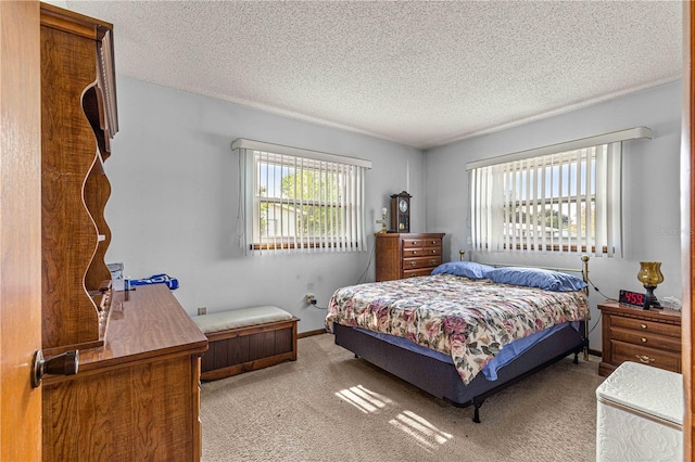 bedroom with a textured ceiling and light carpet