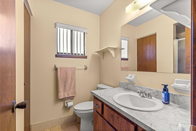 bathroom featuring a textured ceiling, toilet, tile patterned floors, and vanity