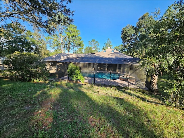 back of house with a lanai, a patio area, and an outdoor pool