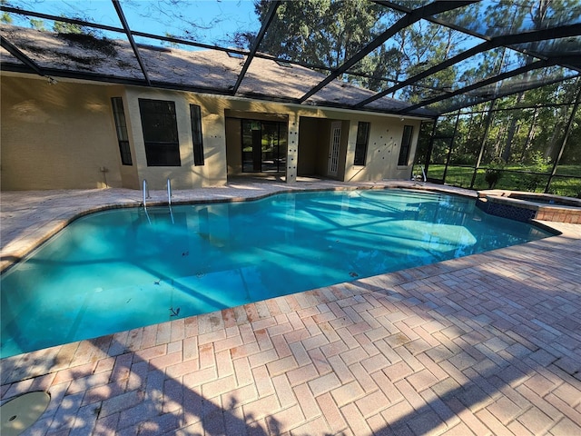 view of pool with glass enclosure, a patio, and an in ground hot tub