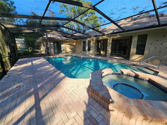 view of swimming pool with glass enclosure, a pool with connected hot tub, and a patio