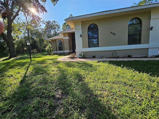 view of front facade with a front lawn and stucco siding