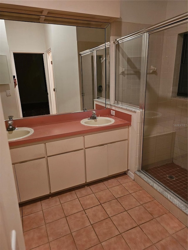 bathroom featuring a shower with shower door, tile patterned floors, and double vanity