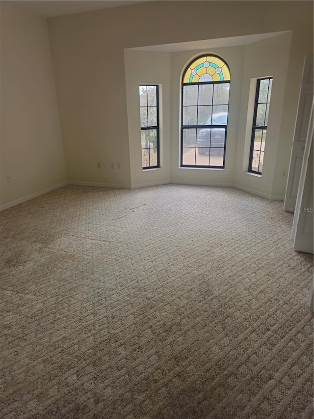 carpeted spare room with baseboards