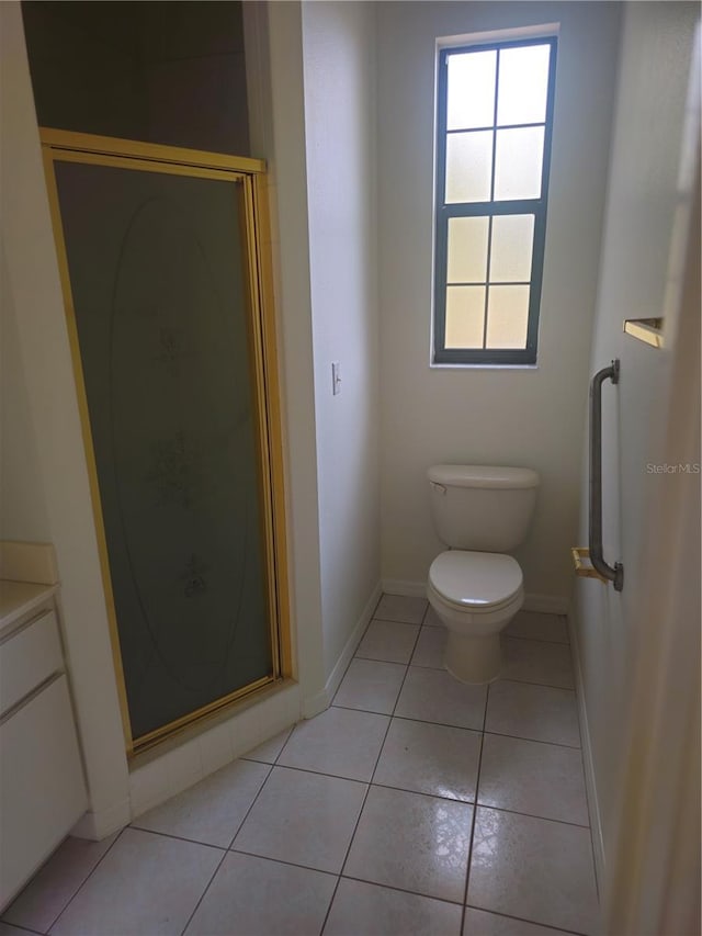 full bath featuring toilet, vanity, baseboards, tile patterned floors, and a stall shower