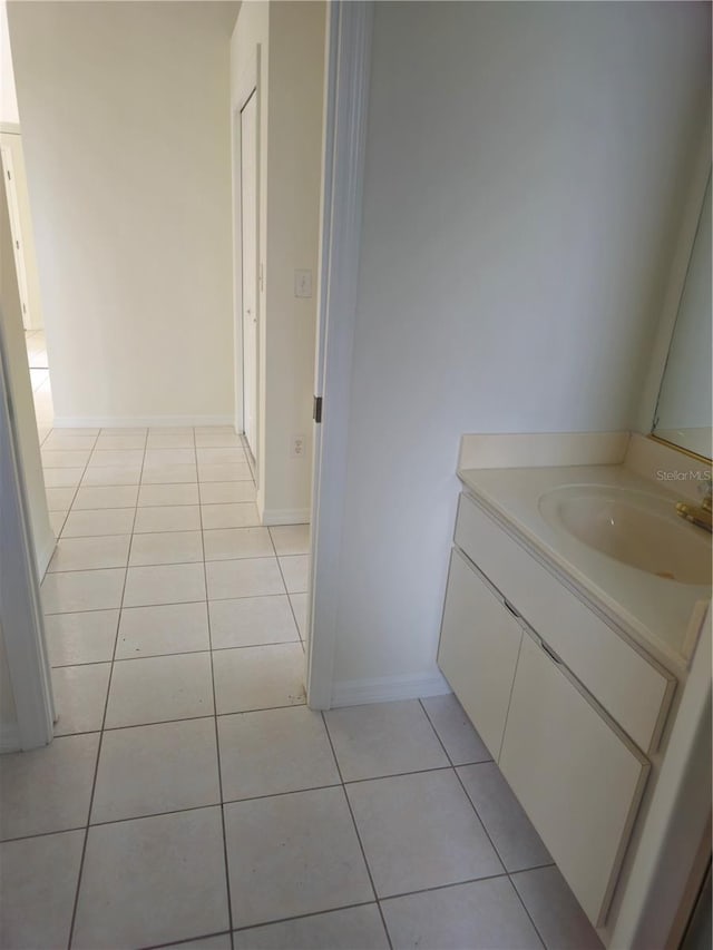 bathroom with vanity, baseboards, and tile patterned floors