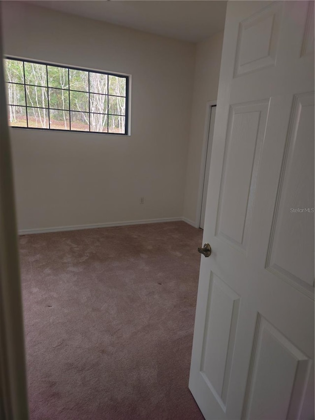 carpeted spare room with baseboards