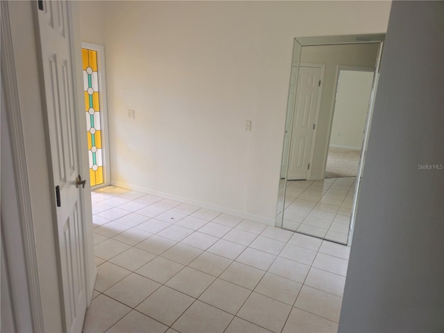 unfurnished room featuring baseboards and light tile patterned floors