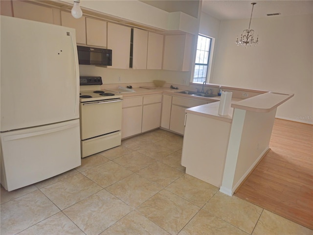 kitchen with white appliances, visible vents, a peninsula, hanging light fixtures, and a sink