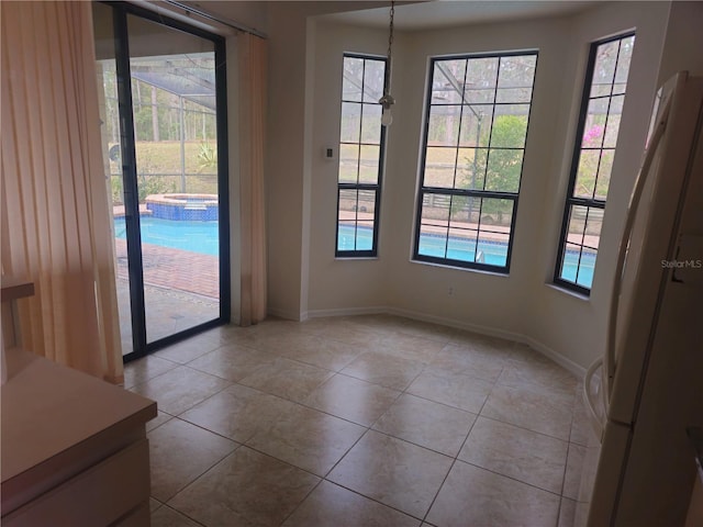 doorway to outside featuring light tile patterned floors, baseboards, and a wealth of natural light