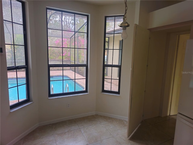 empty room with light tile patterned floors and baseboards