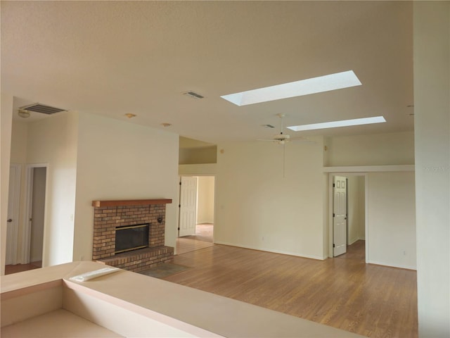 unfurnished living room with a fireplace, visible vents, and wood finished floors