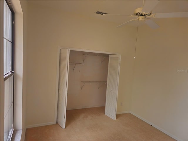 unfurnished bedroom with baseboards, a closet, visible vents, and light colored carpet