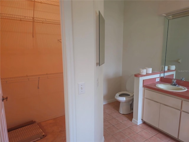 bathroom featuring baseboards, vanity, toilet, and tile patterned floors