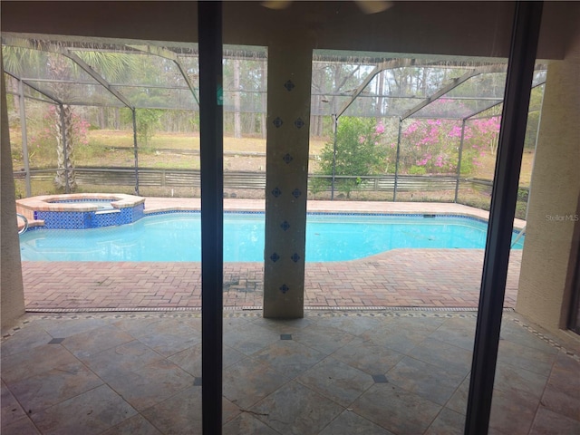 view of swimming pool featuring a patio, a lanai, and a pool with connected hot tub