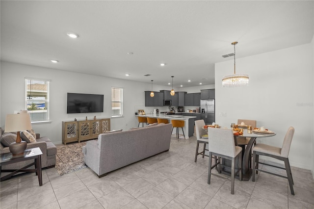 living room featuring light tile patterned flooring and a chandelier