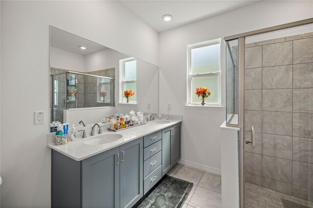 bathroom with tile patterned floors, double vanity, and walk in shower