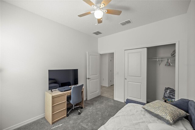 carpeted bedroom featuring ceiling fan, a closet, and a textured ceiling