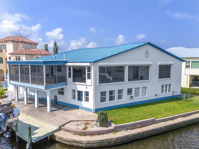 rear view of house featuring a patio, a water view, and a yard