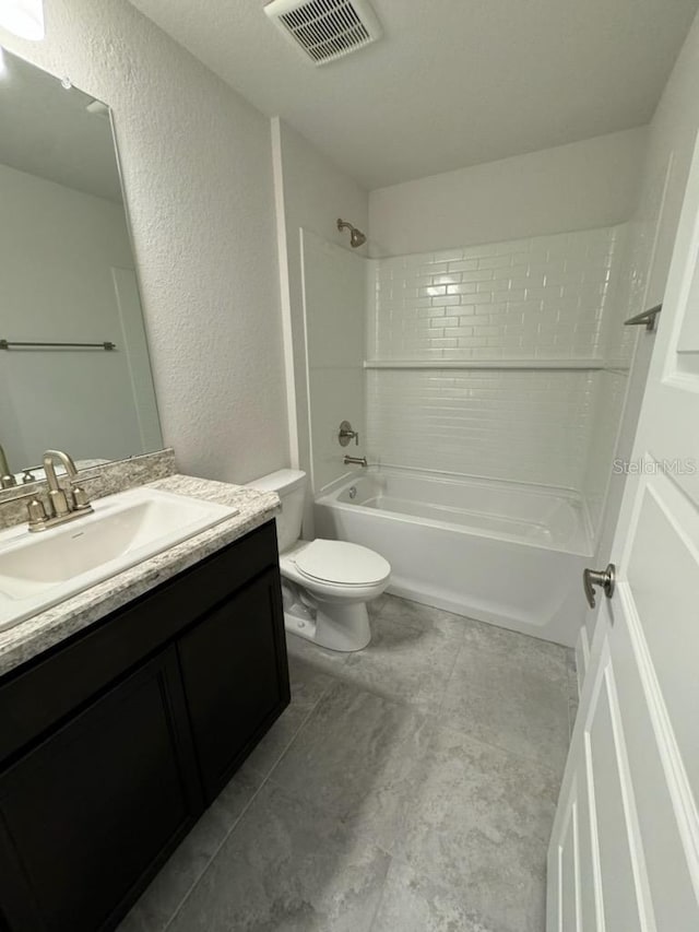 bathroom featuring a textured wall, toilet, vanity, visible vents, and shower / washtub combination