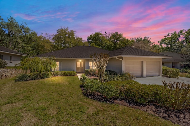 ranch-style home with a yard and a garage