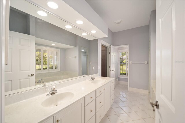 bathroom with vanity, a tub, and tile patterned floors