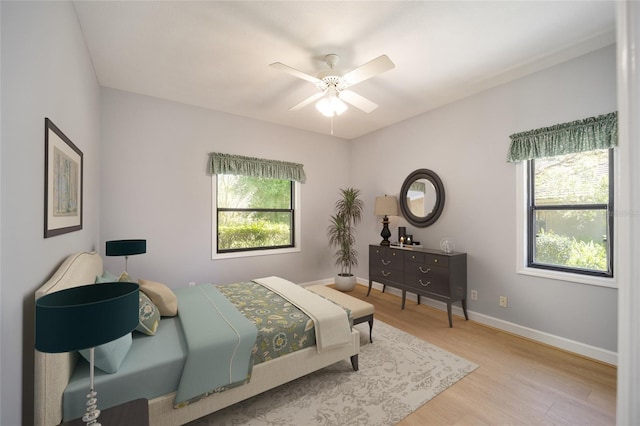 bedroom featuring multiple windows, ceiling fan, and light hardwood / wood-style floors