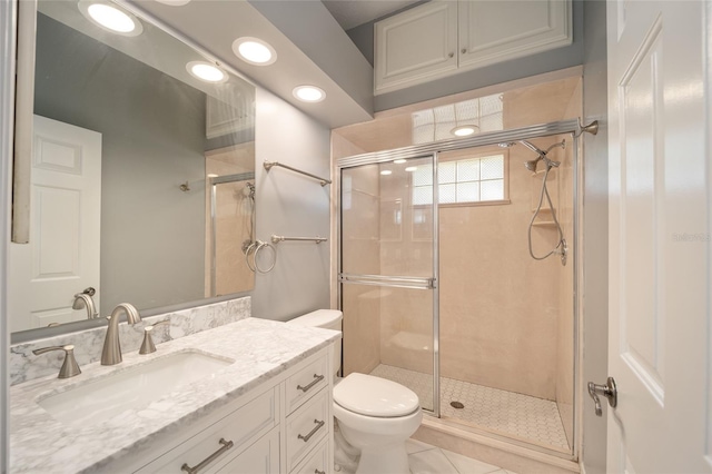 bathroom featuring tile patterned flooring, a shower with shower door, toilet, and vanity