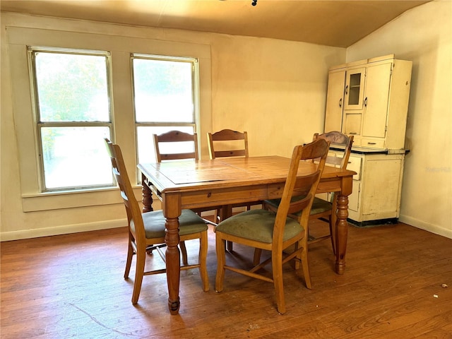 dining room with vaulted ceiling and dark hardwood / wood-style flooring