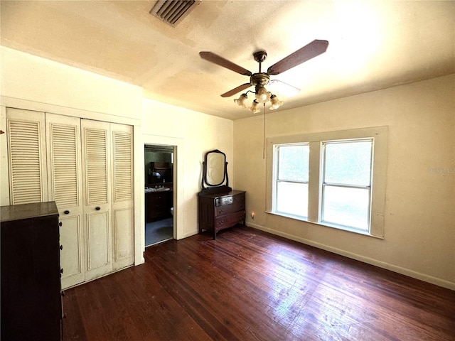 unfurnished bedroom featuring a closet, ceiling fan, and dark hardwood / wood-style flooring