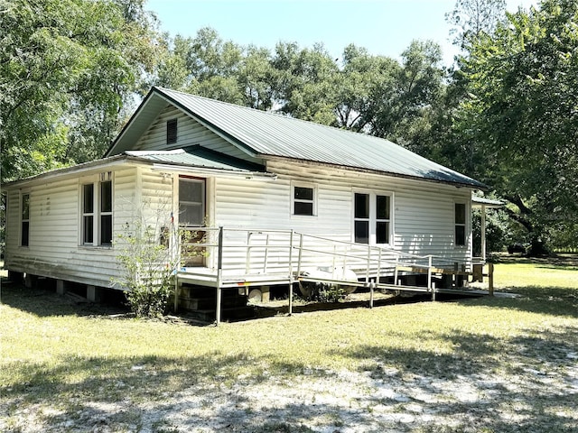 back of property featuring a lawn and a wooden deck