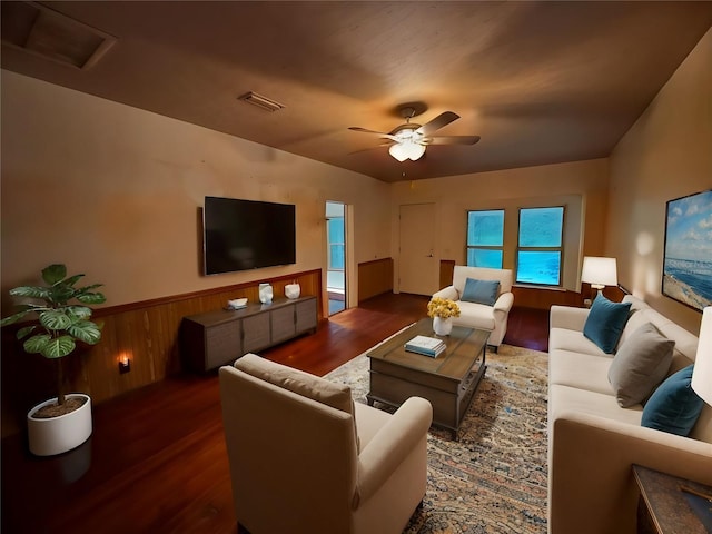 living room with dark wood-type flooring and ceiling fan