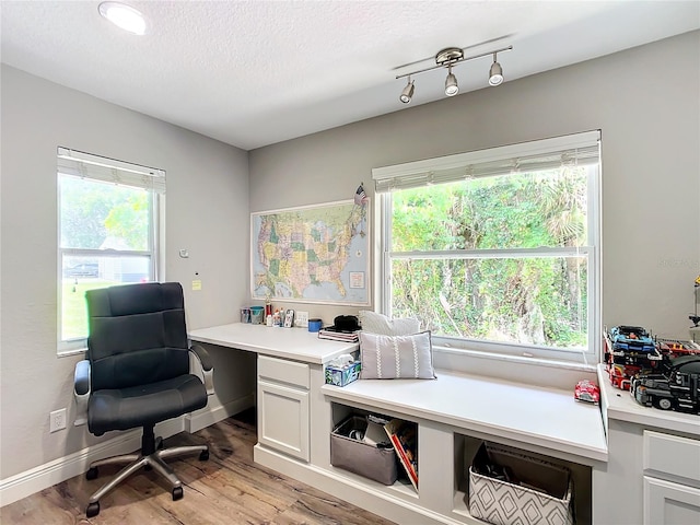 home office featuring a textured ceiling and light hardwood / wood-style flooring