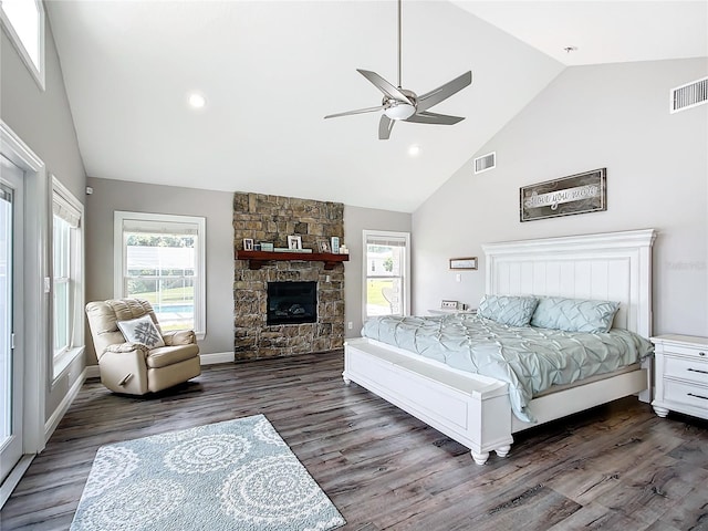 bedroom with dark wood-type flooring, ceiling fan, high vaulted ceiling, and a fireplace