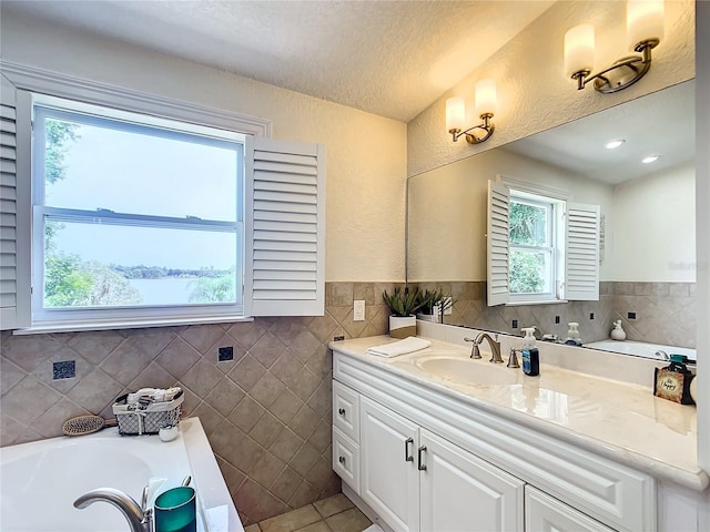 bathroom with vanity, plenty of natural light, and a bathtub