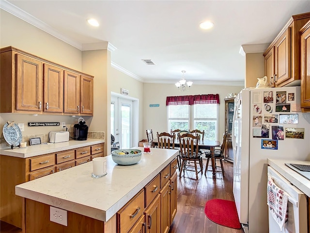 kitchen with a center island, a chandelier, white fridge, dark wood-type flooring, and ornamental molding