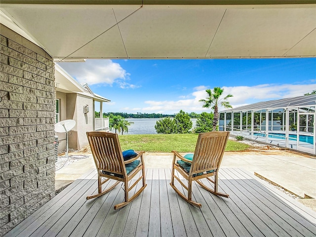 wooden terrace featuring a lanai, a patio area, and a water view