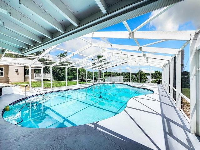 view of swimming pool with glass enclosure and a patio