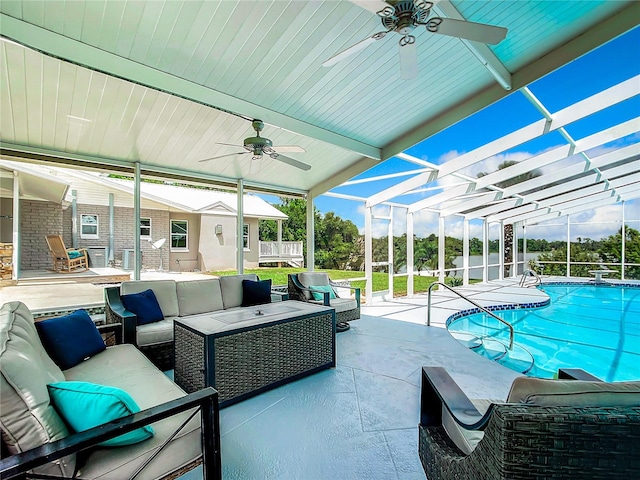 view of swimming pool featuring glass enclosure, ceiling fan, a patio, and an outdoor hangout area