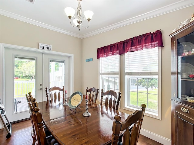 dining area with dark wood-type flooring, an inviting chandelier, crown molding, and french doors