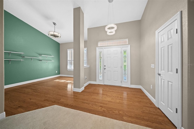 entrance foyer with wood-type flooring and vaulted ceiling