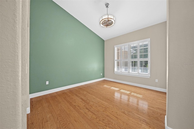 empty room featuring wood-type flooring and lofted ceiling