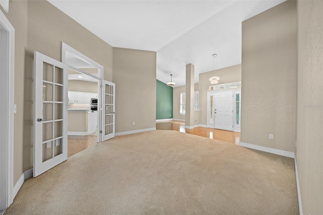 carpeted empty room featuring french doors and lofted ceiling