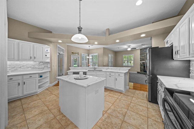 kitchen featuring a kitchen island, decorative light fixtures, white cabinetry, sink, and kitchen peninsula