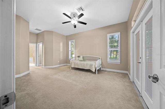 bedroom with light carpet, ceiling fan, and ensuite bath