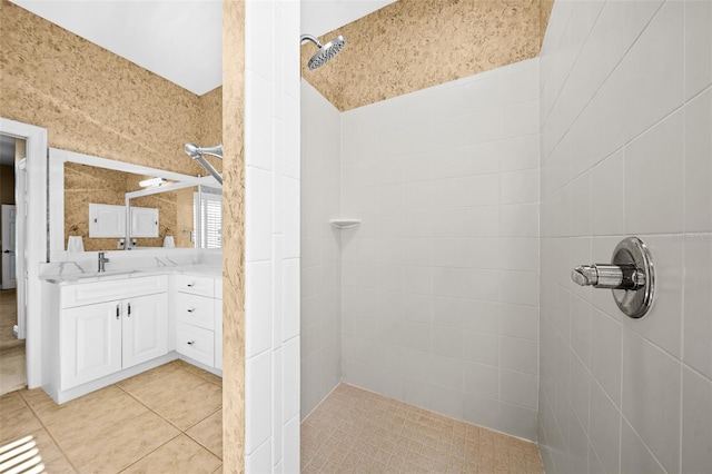 bathroom with vanity, a tile shower, and tile patterned floors